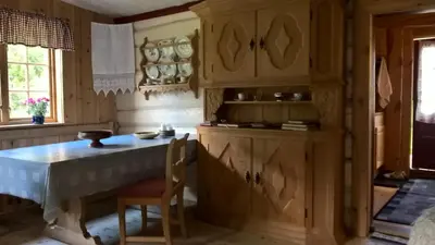 a kitchen with wooden cabinets and a table and chairs at Brekkøye i Lom in Lom