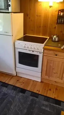 a kitchen with a white stove and a refrigerator at Brekkøye i Lom in Lom