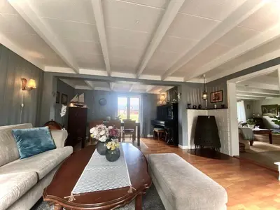 a living room with a couch and a table with flowers on it at Villa Edvin - Slow living in Eide
