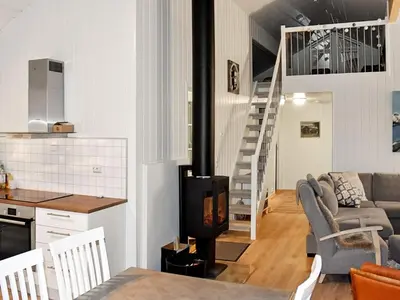 a living room with a fireplace and a stairway at 6 person holiday home in Lyngstad in Lyngstad