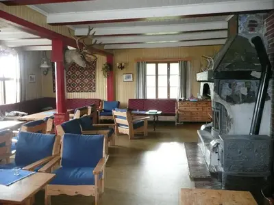 a restaurant with a fireplace and tables and chairs at Jønndalen Høyfjellseter in Uvdal