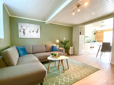 a living room with a couch and a table at Villa Lovise Riverside in Stranda