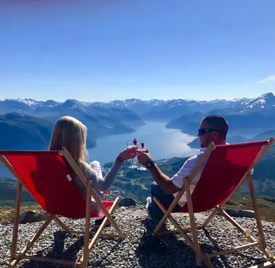 two people sitting in chairs on top of a mountain at Villa Lovise Riverside in Stranda