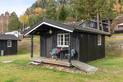 a small black house with a porch and a table at Topcamp Rustberg - Hafjell in Hafjell