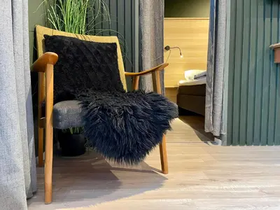 a wooden chair with a furry pillow on it at Apartment Lilletveitvegen in Bergen