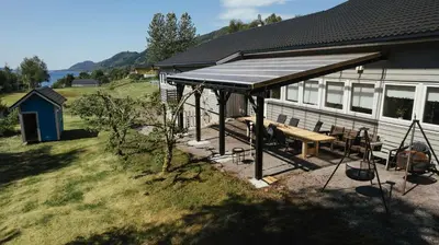 a house with a picnic table and a roof at Sognhostel in Sørbø