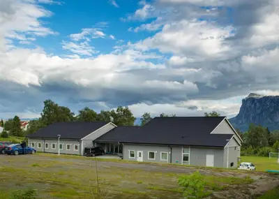 a house with a black roof and a garage at Sognhostel in Sørbø