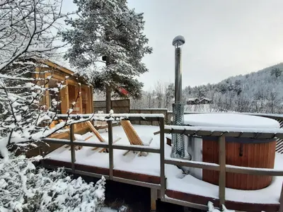 a fence covered in snow with a hot tub at Rondane River Lodge - Rondane Gjestegård in Enden