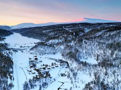 an aerial view of a mountain with snow and trees at Rondane River Lodge - Rondane Gjestegård in Enden