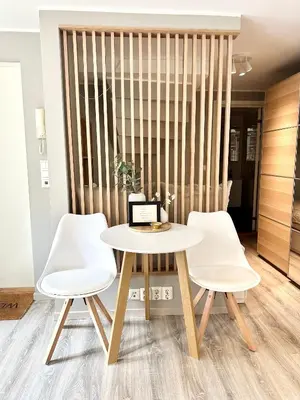 a table and two white chairs in a room at Nedre Stølen Apartment Bergen in Bergen