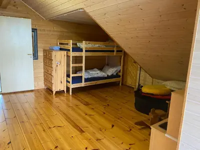 a room with two bunk beds and a wooden floor at Skjerping gårdshus, in Lonevåg