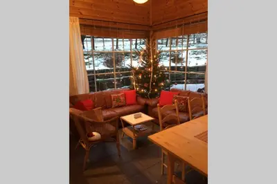 a living room with a couch and a christmas tree at Skjerping gårdshus, in Lonevåg