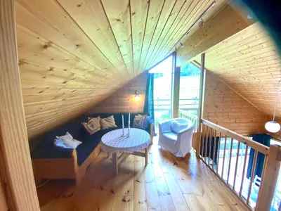 an attic room with a wooden ceiling and a table at Skjerping gårdshus, in Lonevåg