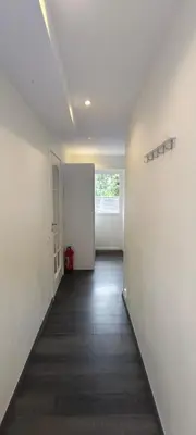 an empty room with a hallway with white walls at Lagunen Apartments in Bergen