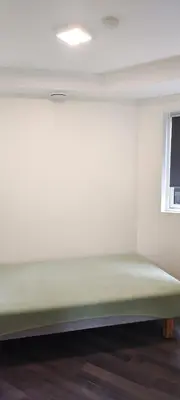 a green bed in a room with a window at Lagunen Apartments in Bergen