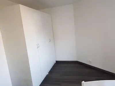 an empty room with white walls and wooden floors at Lagunen Apartments in Bergen