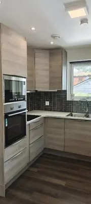 a large kitchen with wooden cabinets and a window at Lagunen Apartments in Bergen