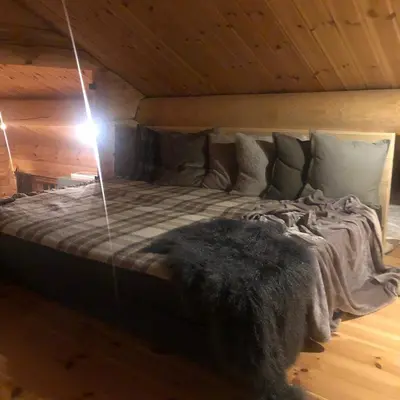 a large bed in a room with a wooden ceiling at Hyggelig laftehytte på 140kvm med Ski-In/Out in Uvdal