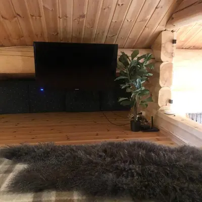 a living room with a flat screen tv and a furry rug at Hyggelig laftehytte på 140kvm med Ski-In/Out in Uvdal
