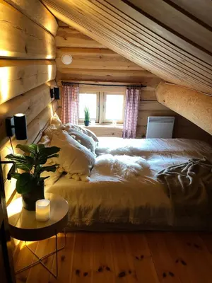 a bed in a room with a wooden wall at Hyggelig laftehytte på 140kvm med Ski-In/Out in Uvdal