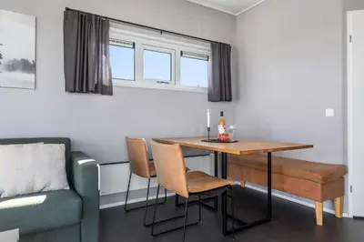 a dining room with a table and chairs and a couch at Topcamp Mjøsa - Brumunddal in Brumunddalen