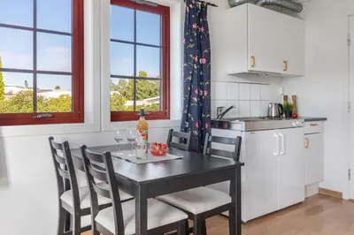 a kitchen with a table and chairs in a kitchen at Topcamp Mjøsa - Brumunddal in Brumunddalen