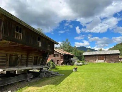 a log cabin in a field next to two buildings at Sevletunet B&B and Cabins in Rødberg