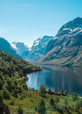 a view of a lake with snow covered mountains at Hotel Loenfjord Loen in Loen