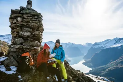 two women sitting on the top of a mountain at Hotel Loenfjord Loen in Loen