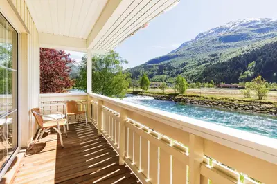 a balcony with a view of a river and mountains at Hotel Loenfjord Loen in Loen