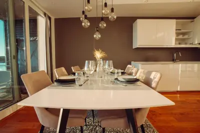 a dining room with a white table and chairs at Panorama Rorbusuiter in Steinsland