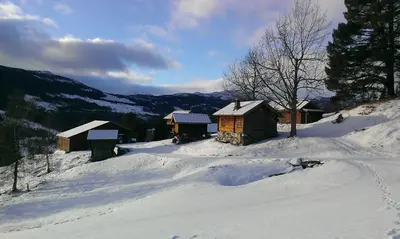 a group of cabins on a snow covered mountain at Gamlestugu Greivjord Fjellgard in Tuddal