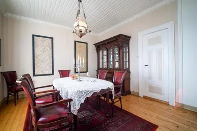 a dining room with a table and chairs and a chandelier at Flatflesa Fyr - by Classic Norway Hotels in Rindarøy