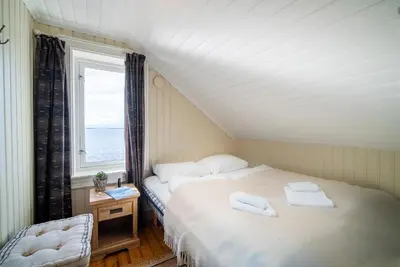 a bedroom with a bed with two towels on it at Flatflesa Fyr - by Classic Norway Hotels in Rindarøy