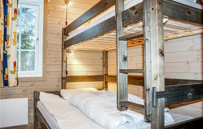a bunk bed in a log cabin with a ladder at Privat'n in Hemsedal