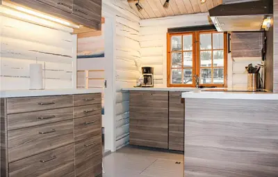 a kitchen with wooden cabinets and a window at Privat'n in Hemsedal