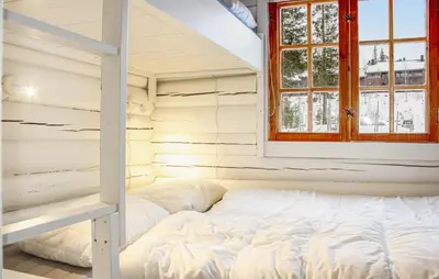 a white bed in a room with a ladder at Privat'n in Hemsedal