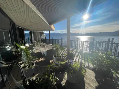 a porch with plants and a view of the water at Panoramaresort in Hardangerfjorden leilighet i sjøkanten ved Hardangerfjorden for 7 personer boat , sauna,kajak, SUP for rent in Øystese