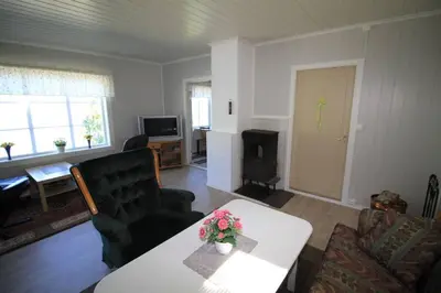a living room with a couch and a table at Bellahuset in Sæbø
