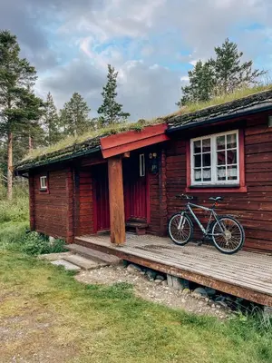 a bike parked on the porch of a cabin at Ryen Hytteutleie - Cottages in Røros