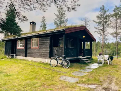 a house with a bike parked in front of it at Ryen Hytteutleie - Cottages in Røros