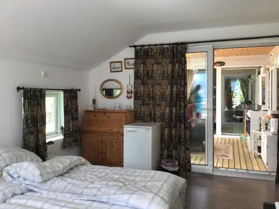 a bedroom with a bed and a sliding glass door at Iris Vedal in Nauste
