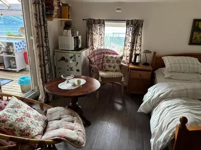 a bedroom with a bed and a table and a bed and a window at Iris Vedal in Nauste