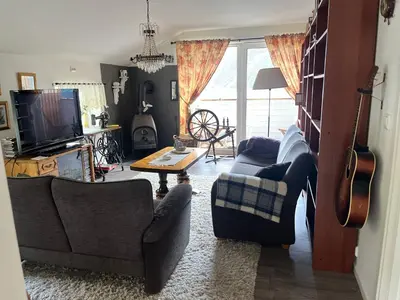 a living room with two couches and a guitar at Iris Vedal in Nauste