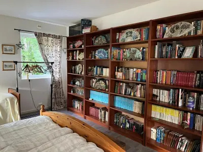 a bedroom with wooden book shelves filled with books at Iris Vedal in Nauste