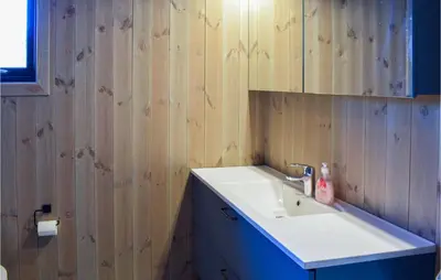 a bathroom with a white sink and wooden walls at Amazing Home In Flå With Wifi in Flå