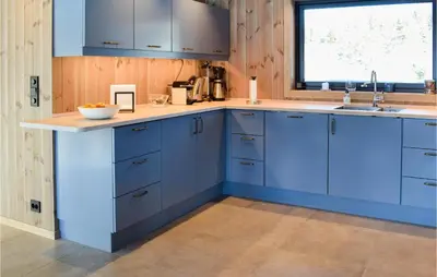 a kitchen with blue cabinets and a window at Amazing Home In Flå With Wifi in Flå