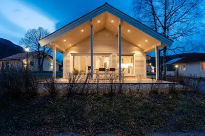 a small house with a porch at night at Jølstraholmen Landskapshotell in Vassenden