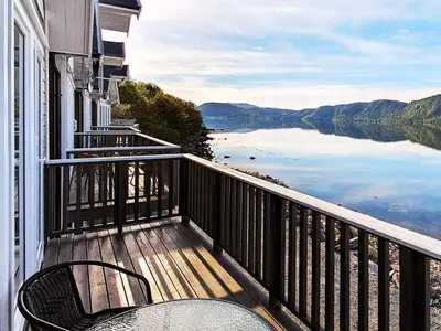 a balcony with chairs and a view of a lake at 6 person holiday home in VATNE in Vatne