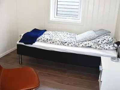 a bed with two books on it in a room at 6 person holiday home in VATNE in Vatne